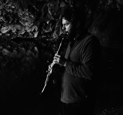 A person playing a clarinet in a cave