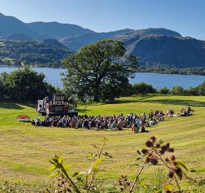 outdoor theatre in a field by a lake