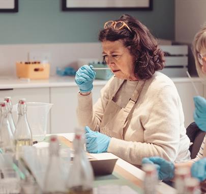 a women smelling a scent stick during a candle making workshop