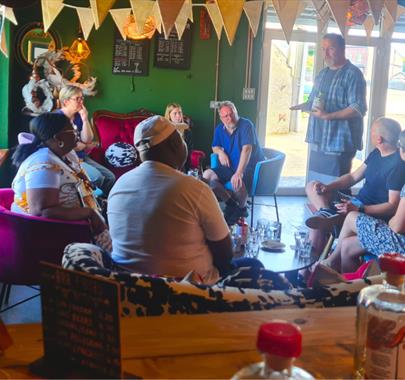 A man giving a talk to a group of people sat down on chairs