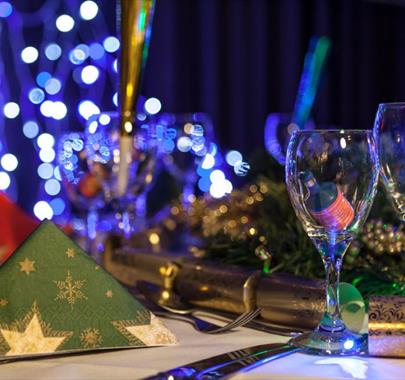 Picture of a Christmas party dinning table with crackers and fairy lights