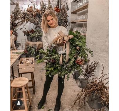 A girl holding a Christmas wreath