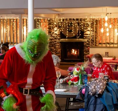 Photo of the Grinch at The Swan Hotel & Spa looking at a Christmas tree