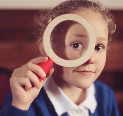 Child with a Magnifying Glass, Advert for The Wild Escape at Quaker Tapestry Museum in Kendal, Cumbria