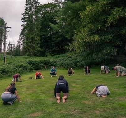 photo of people laying down in a circle in a field
