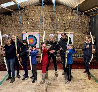 Family doing archery at Newlands Adventure Centre in the Lake District, Cumbria