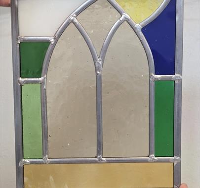a person holding up a stained glass window