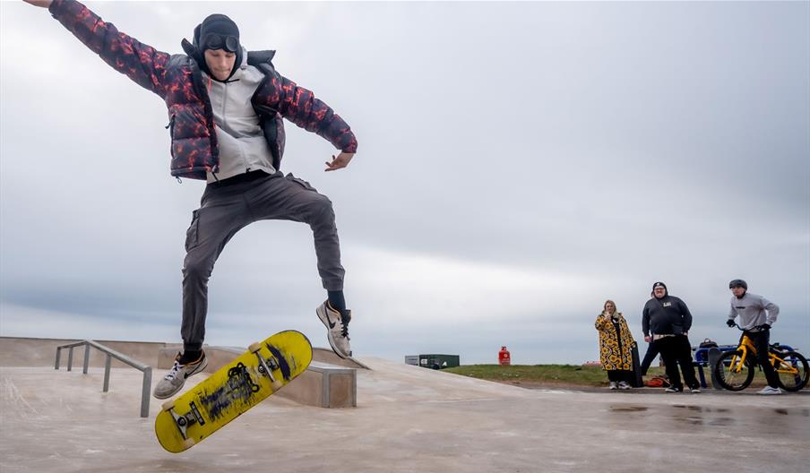 Visitor doing skateboard tricks at Maryport Skate Park in Maryport, Cumbria