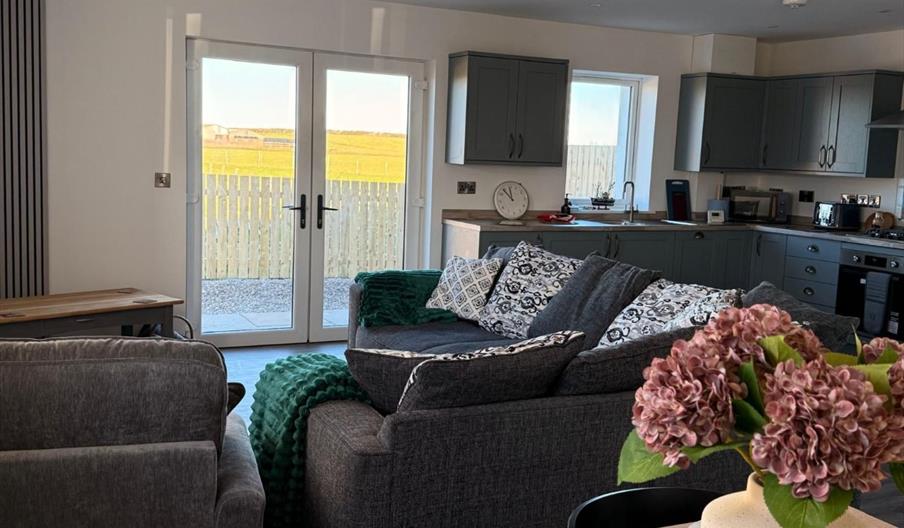Interior view of Old Kiln Cottage showing open plan lounge, kitchen, diner and views of countryside through double glass doors