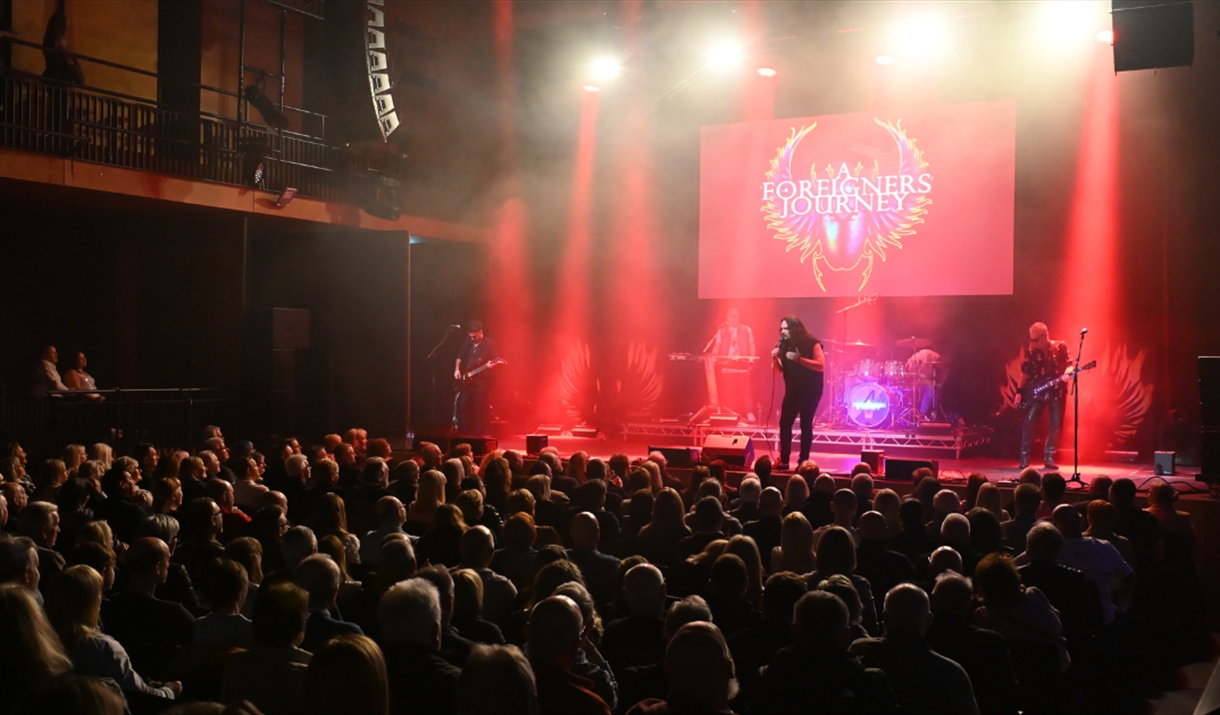 Photograph of audience watching a member of the band play guitar on stage