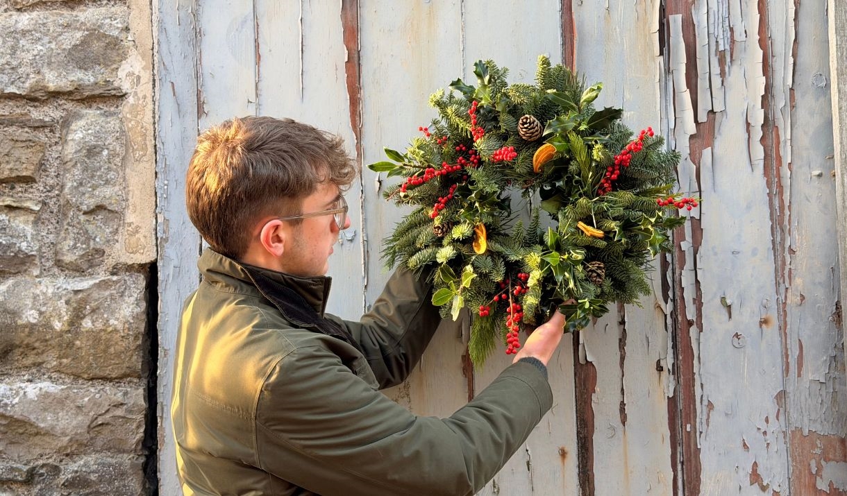 Dan (RHS Gold Medallist from Dan's Plants) holding up a traditional fresh Christmas wreath, one like you would make at Dan's Plants Christmas Wreath W