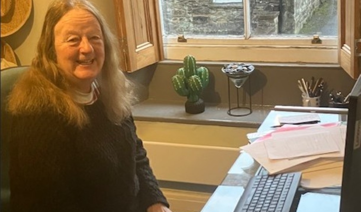 A photograph of speaker Val Fermer at a desk
