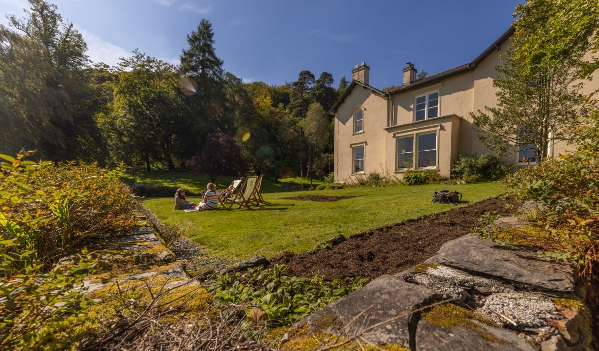 A family enjoys a picnic on the lawn at Allan Bank