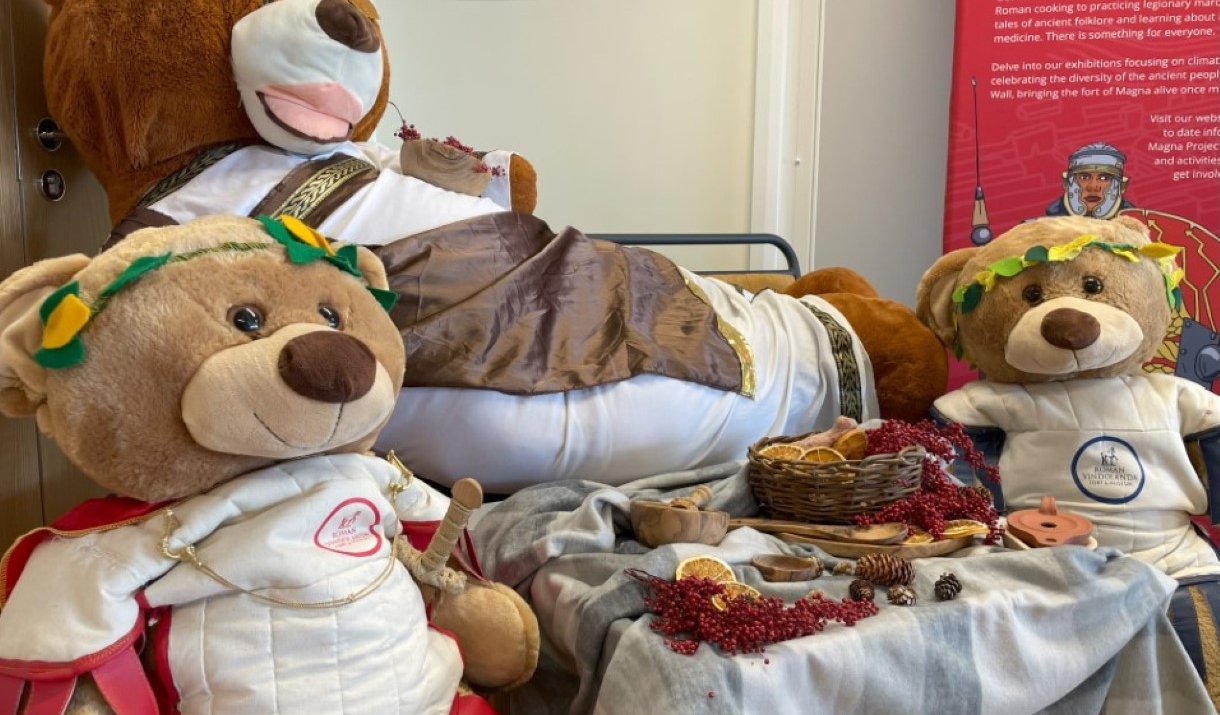 Image of three large teddy bears dressed up as Roman Emperors sitting around a picnic.
