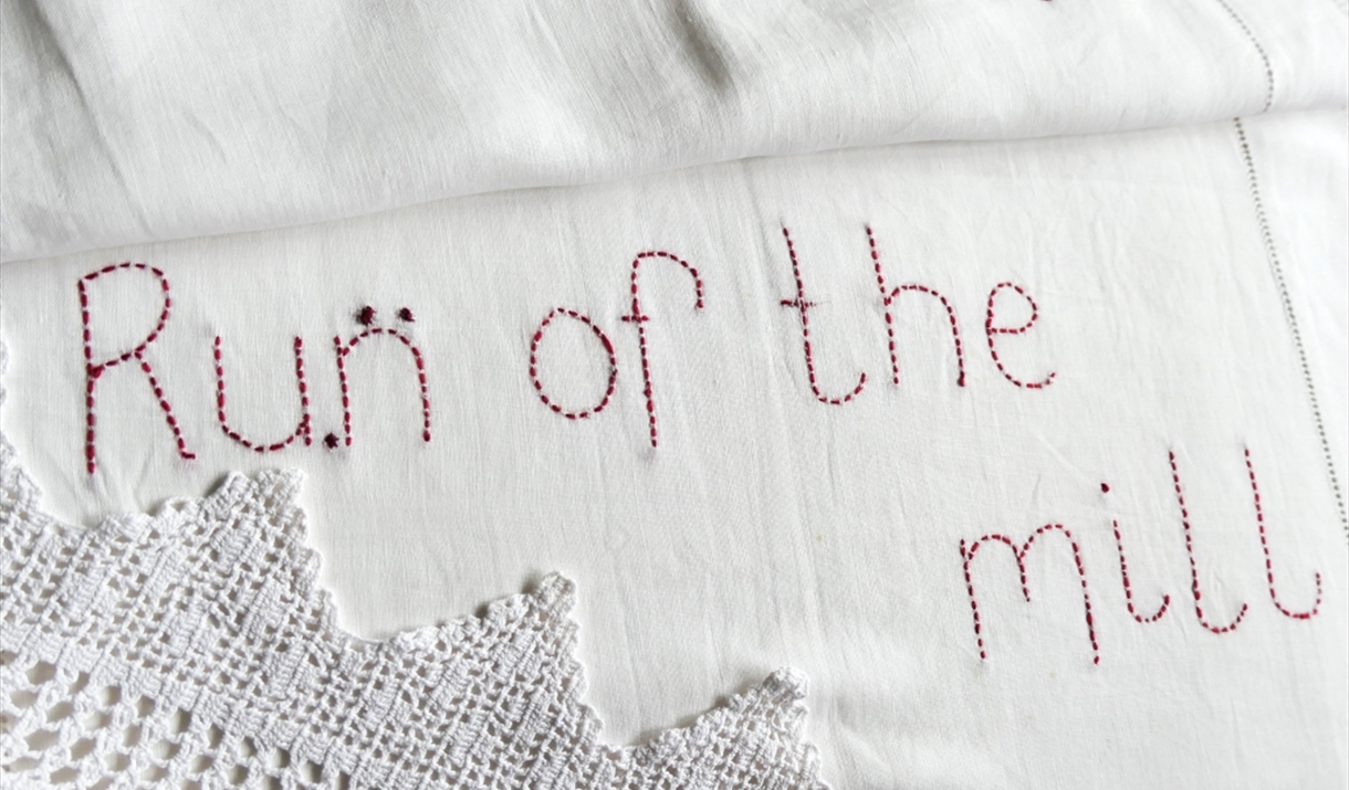 white cloth embroidered with the words run of the mill
