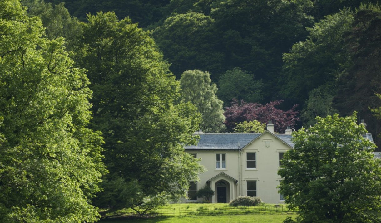 House in the distance tucked between green trees