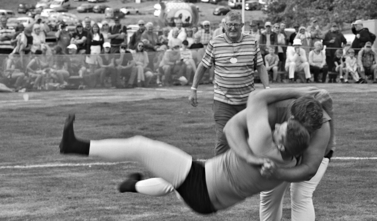 Black and white image of two people wrestling