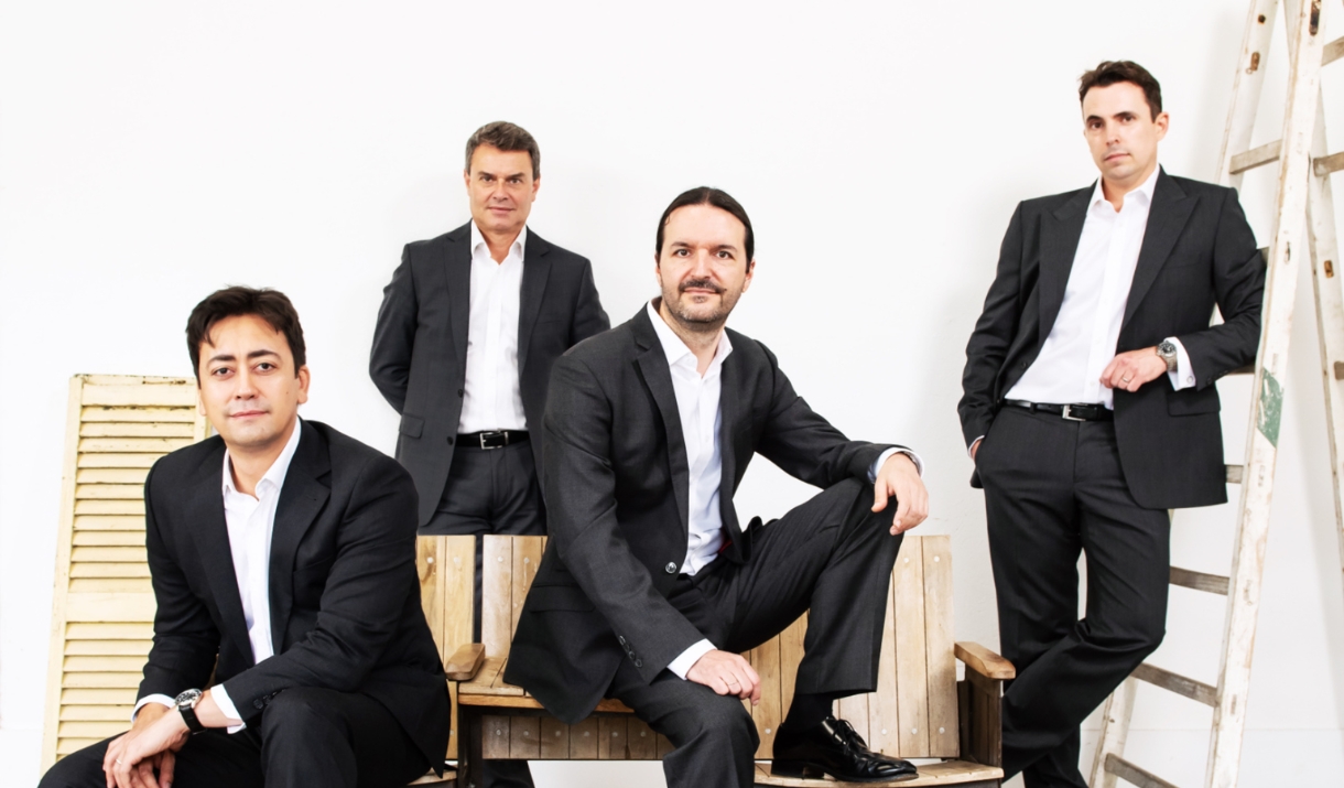 Aquarelle Guitar Quartet stood and sat on wooden benches