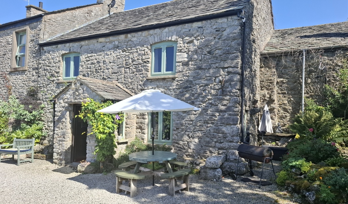 Exterior and outdoor seating at The Old Farmhouse at Brackenthwaite Farm near Arnside