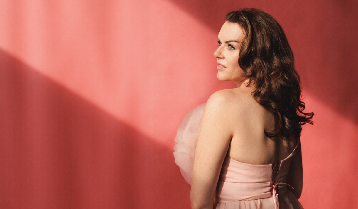 Kirsty McClean posing beautifully in front of a pink wall