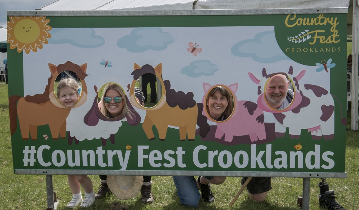 Visitors pose at a photo board at Country Fest in Crooklands, Cumbria