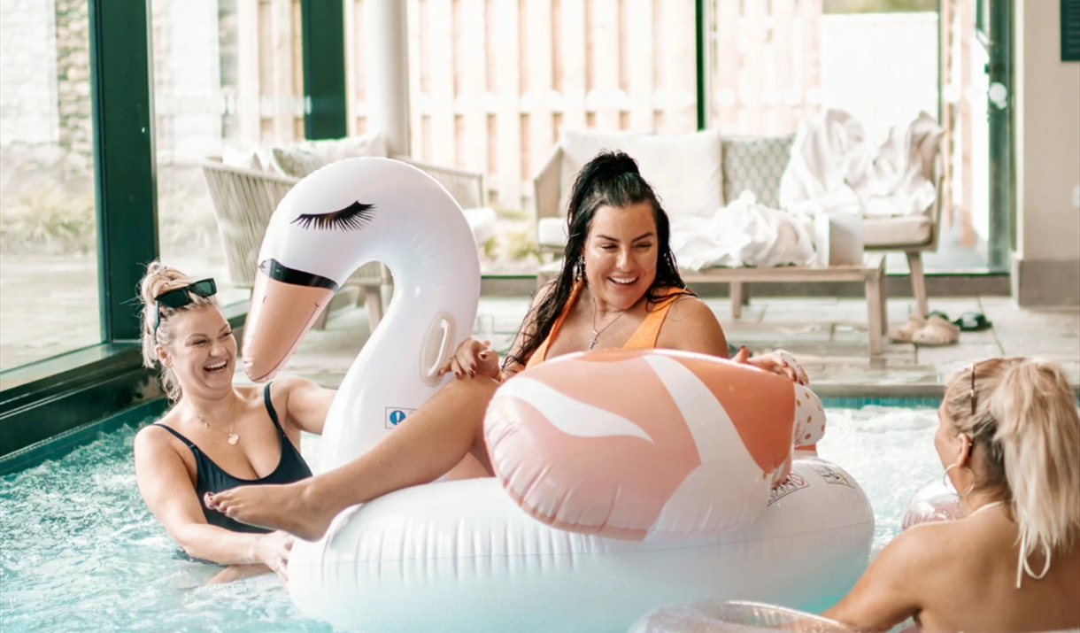 people on a float in a pool smiling