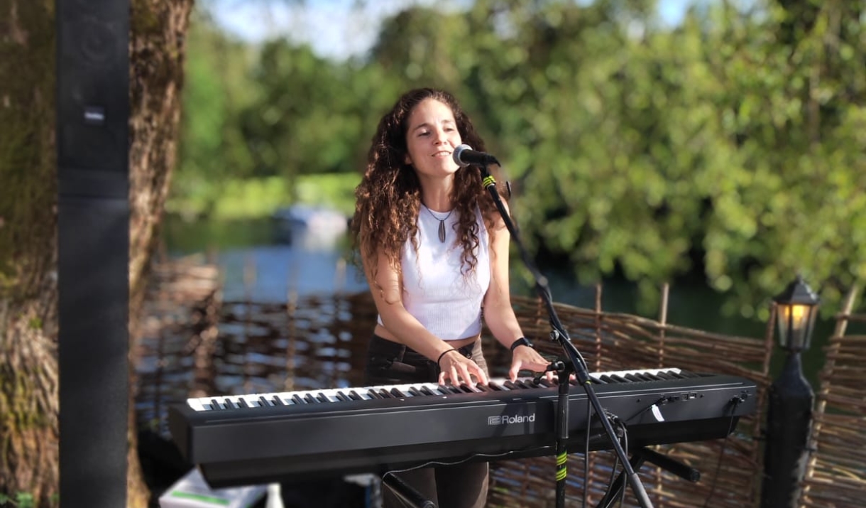 Evie Plumb playing the keyboard while singing