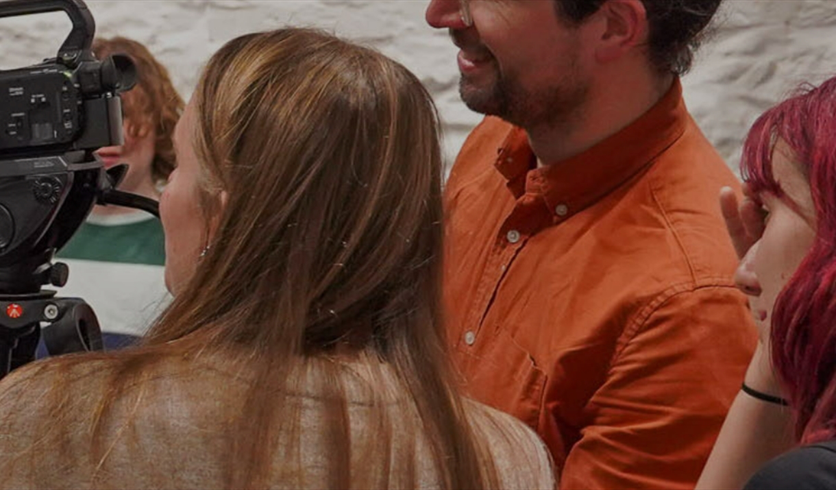 A film crew looing at a camera