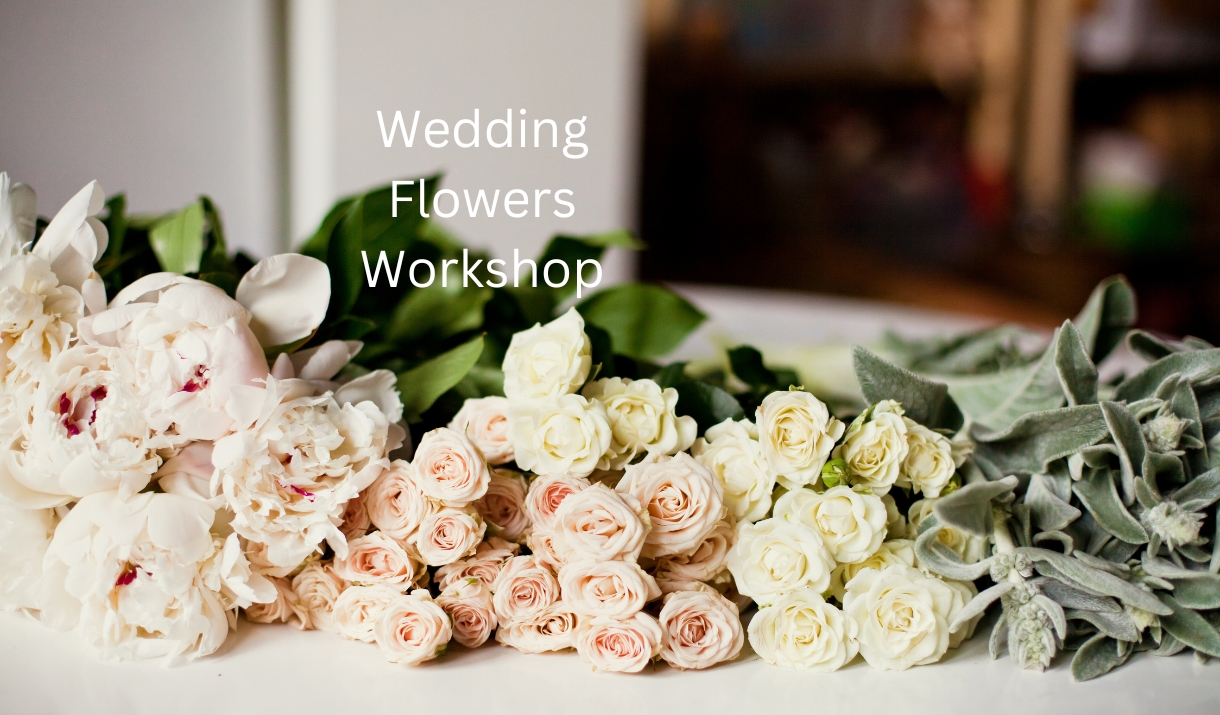 White and pink roses laid on a table, with the words "Wedding Flowers Workshop"