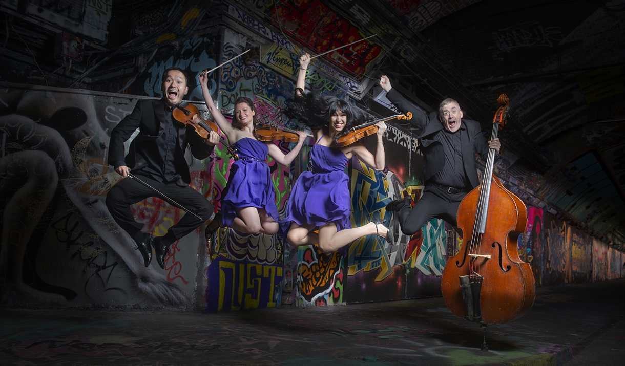 Graffiti Classics band jumping with their instruments 
