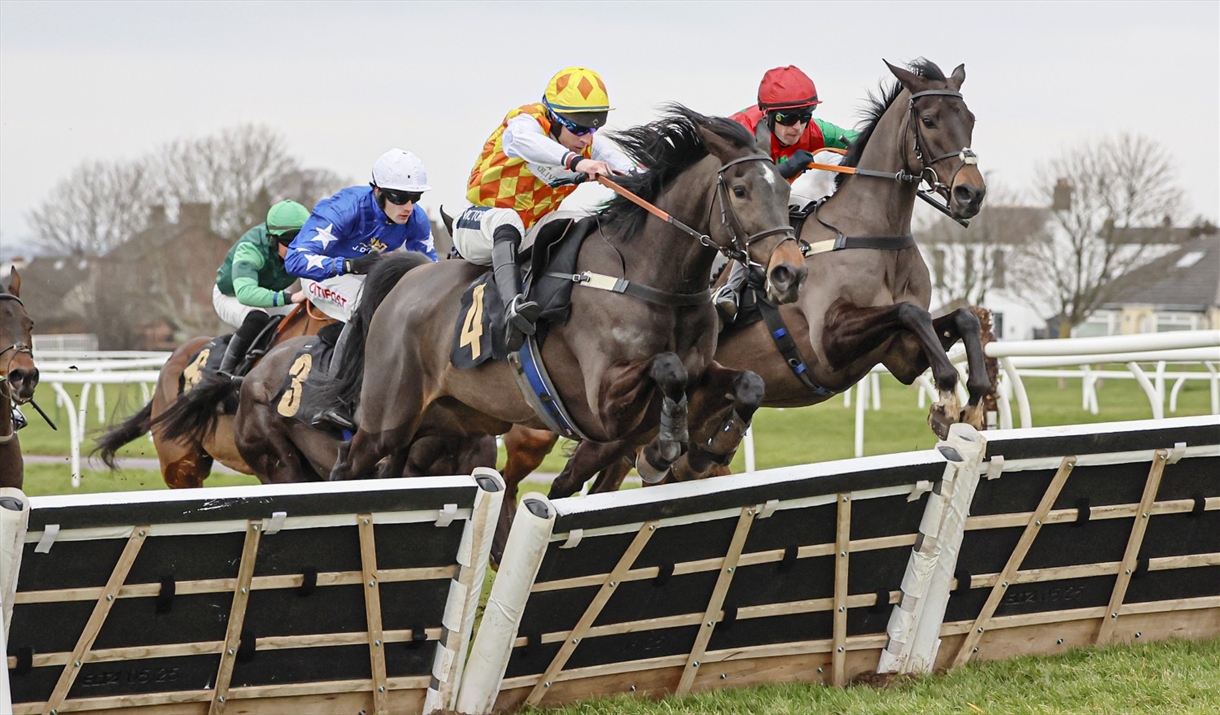 Racehorses and jockeys hurdling during a race at Carlisle Racecourse in Carlisle, Cumbria