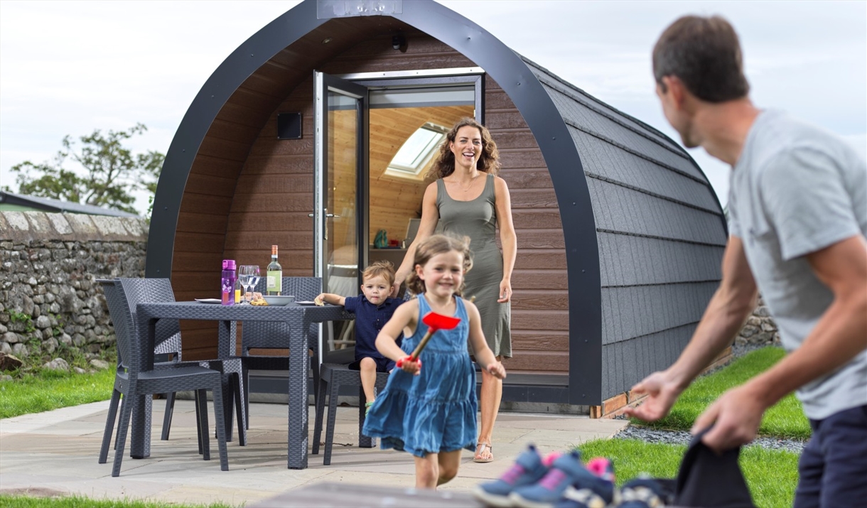 Family at a glamping pod at Holgates Holiday Park in Silverdale, Cumbria