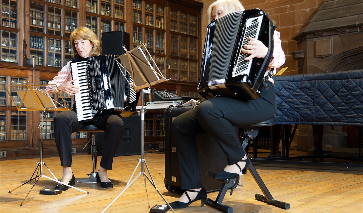 Julie Best and Jean Corrighan playing the Accordion in a library