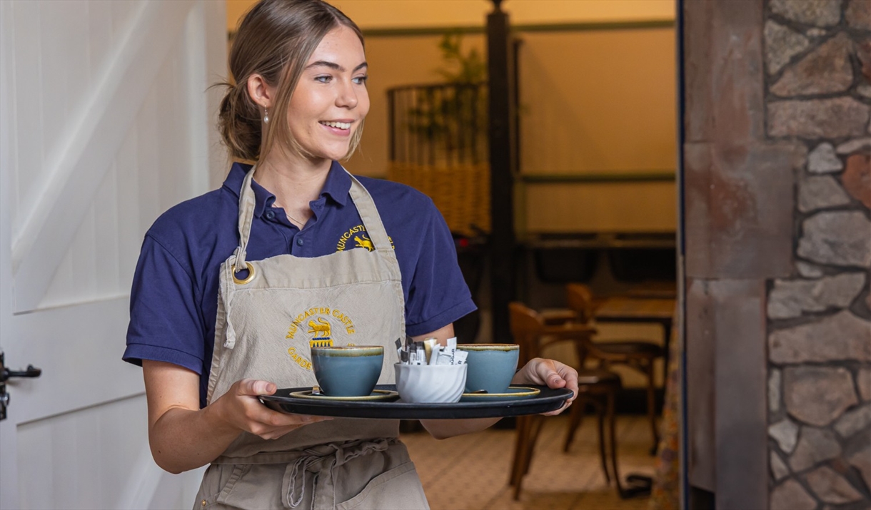 Staff serving drinks at The Stables Café at Muncaster Castle near Ravenglass, Cumbria