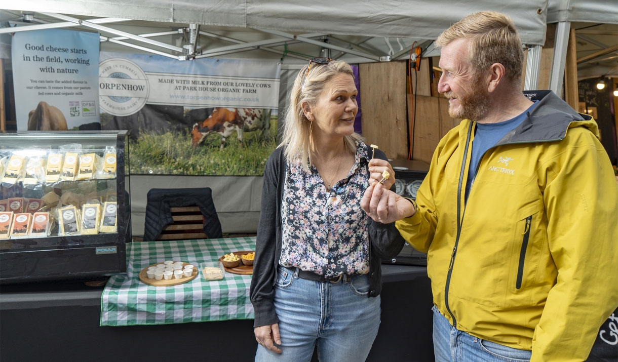 Visitors at a Stall at Keswick Saturday Market in the Lake District, Cumbria