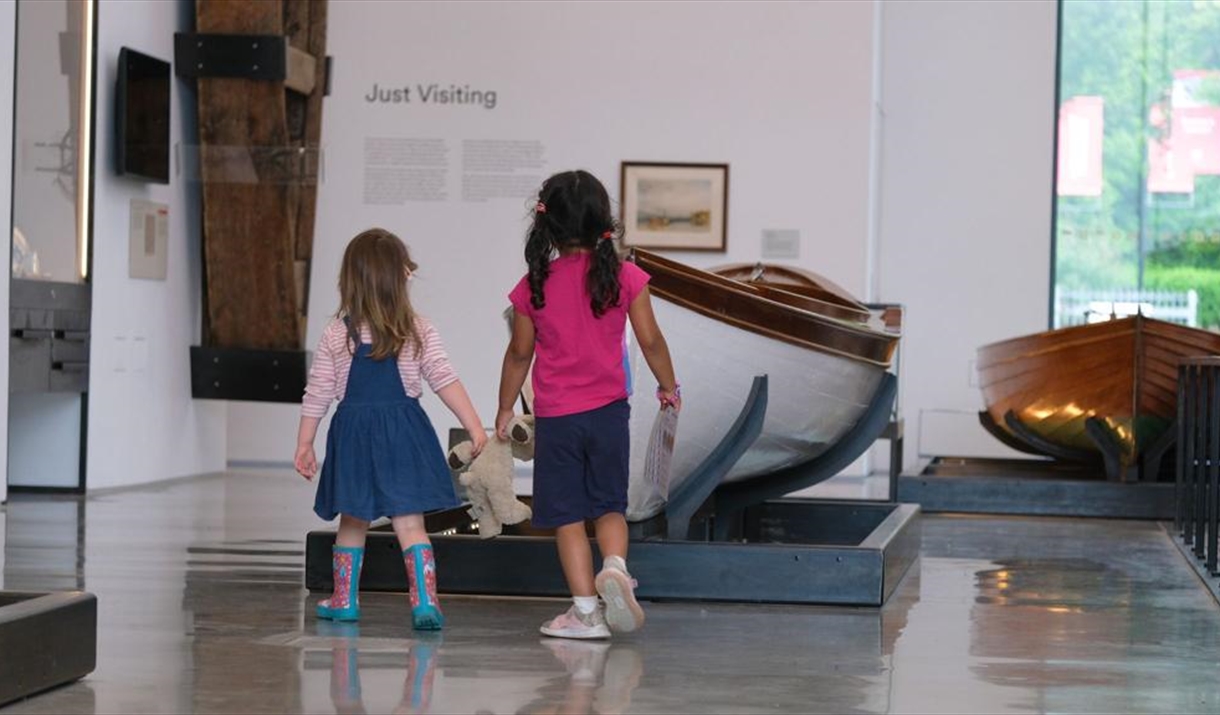 Two children walking through the Windermere Jetty Musem