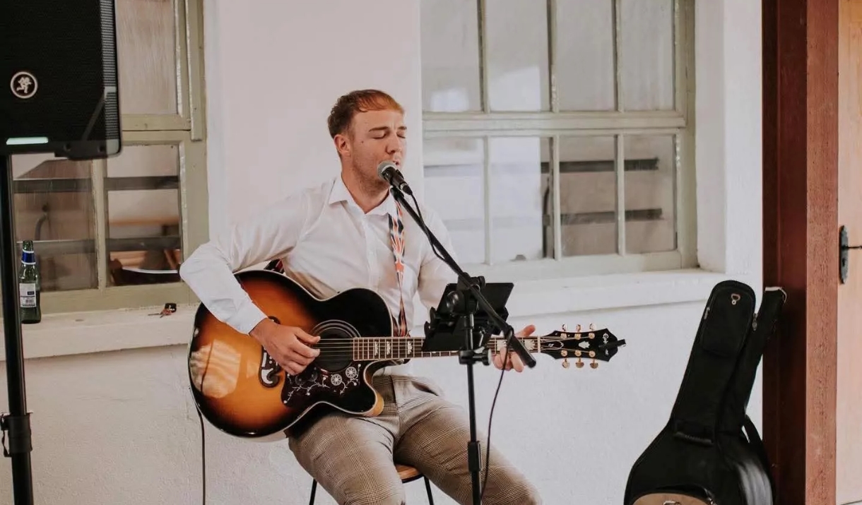 Person sitting on chair playing guitar