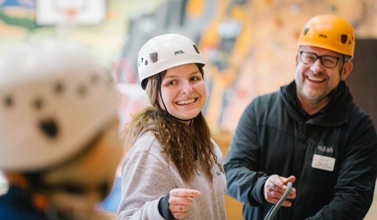Visitors rock climbing indoors with Lake District Calvert Trust