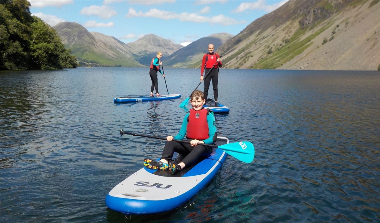 Visitors Paddleboarding in the Lake District with Path to Adventure