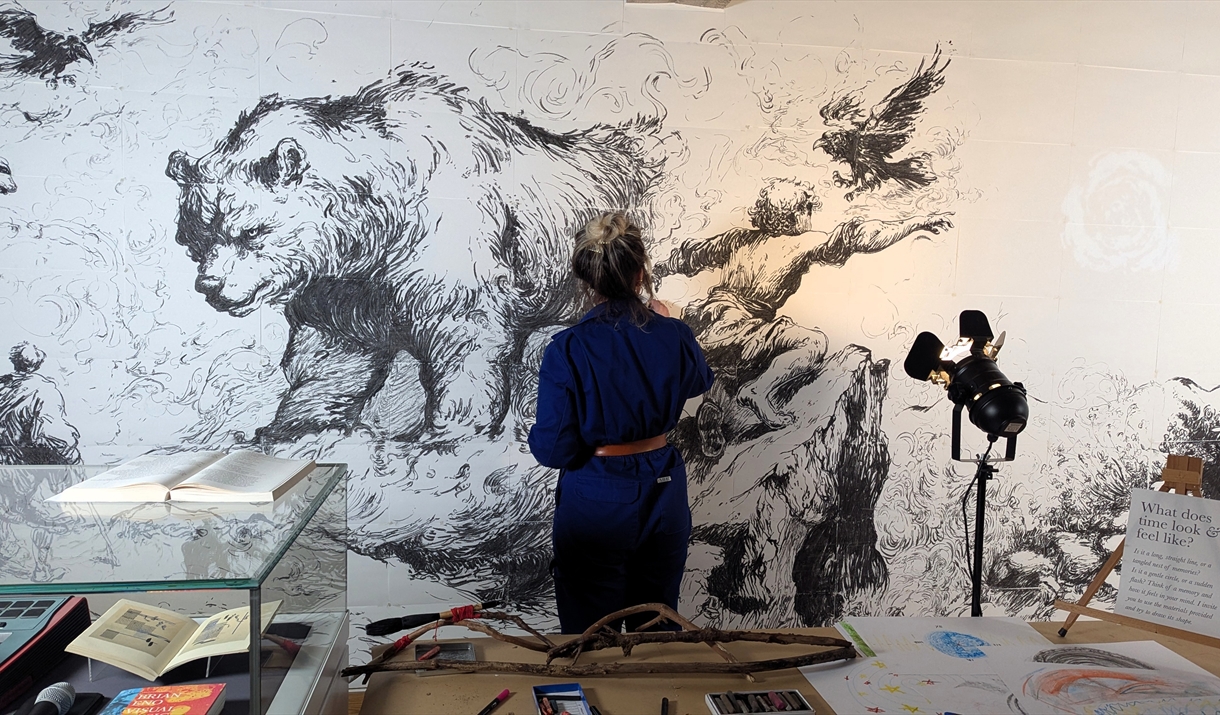 Stacey Joy Rossouw painting a bear on a wall
