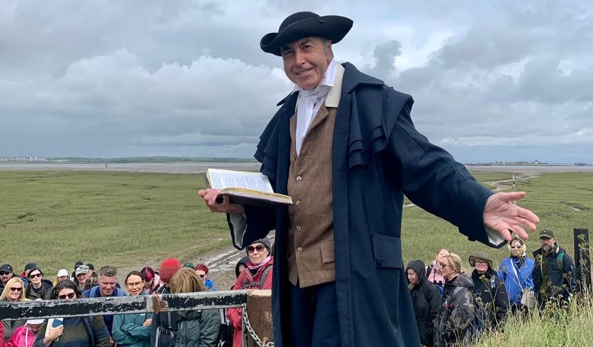 Photograph of a man in 18th century costume reading poetry.