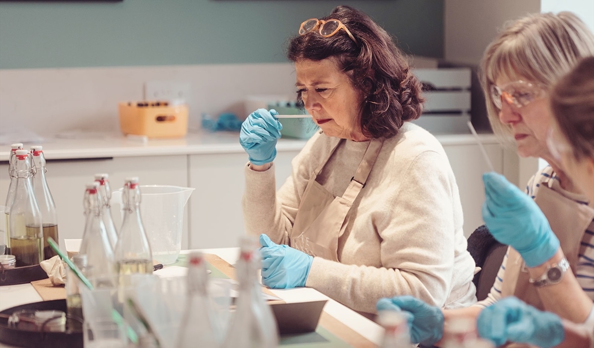 a women smelling a scent stick during a candle making workshop