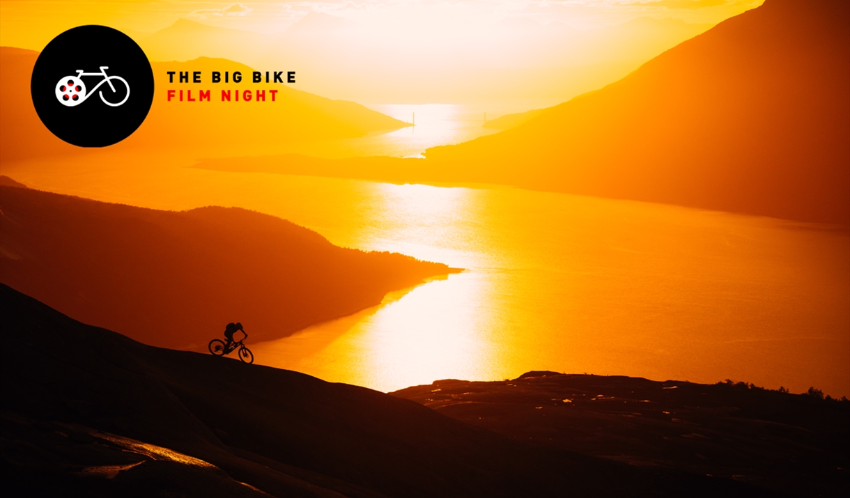 Mountain biker riding at midnight in Norway on slab rocks