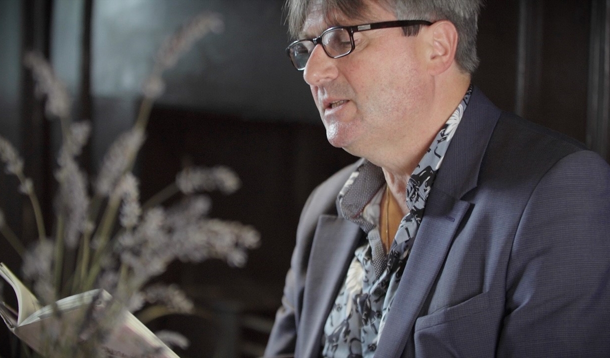 Photograph of Simon Armitage reading from his poetry collection