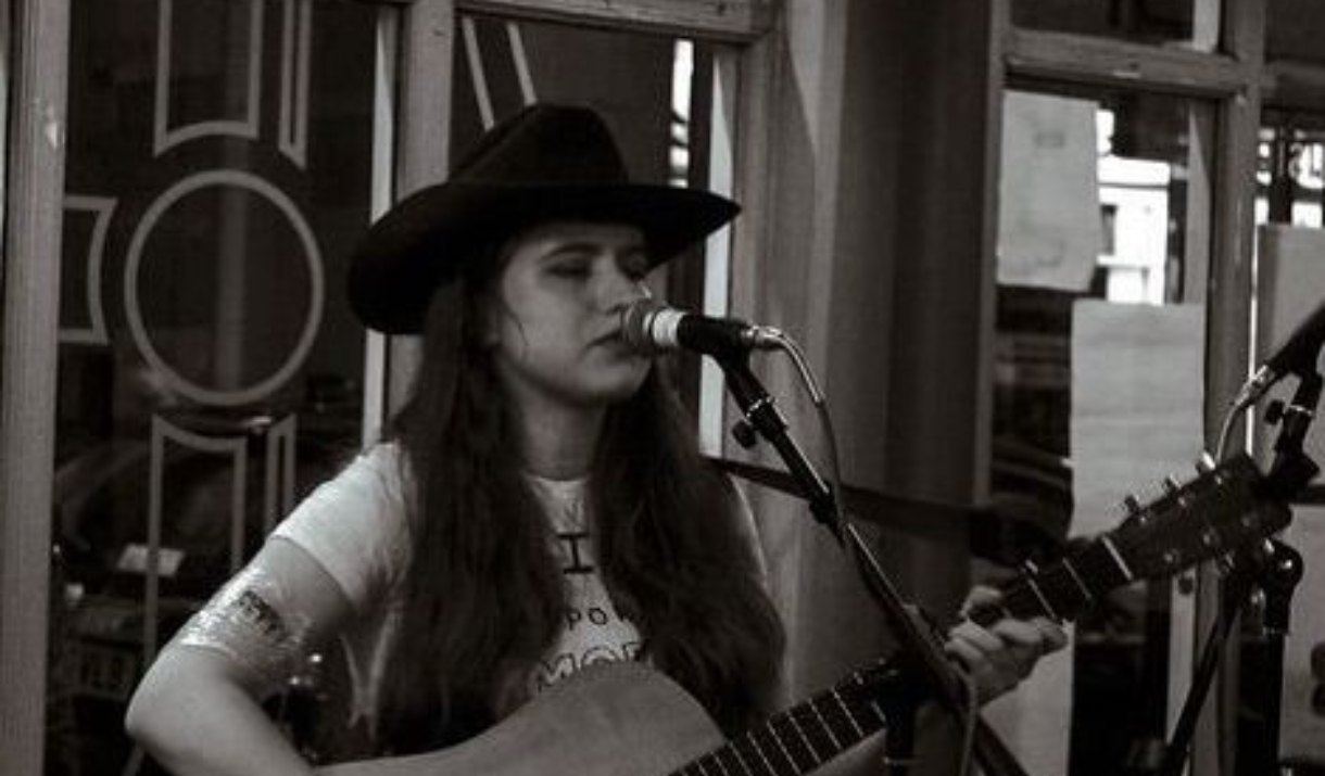 Person playing guitar and singing into mic