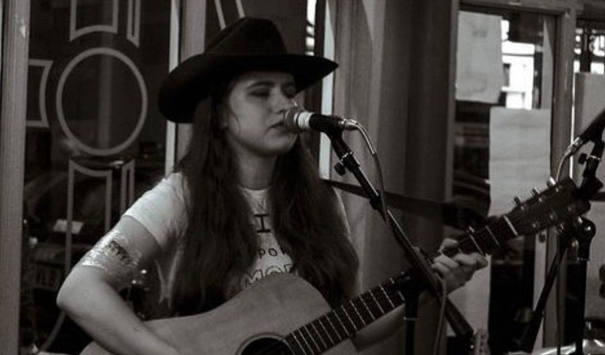 Susannah Clegg singing live while playing the guitar