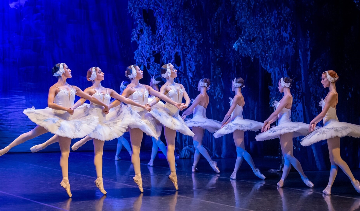A still from the ballet "Swan Lake". showing a group of 9 ballerinas