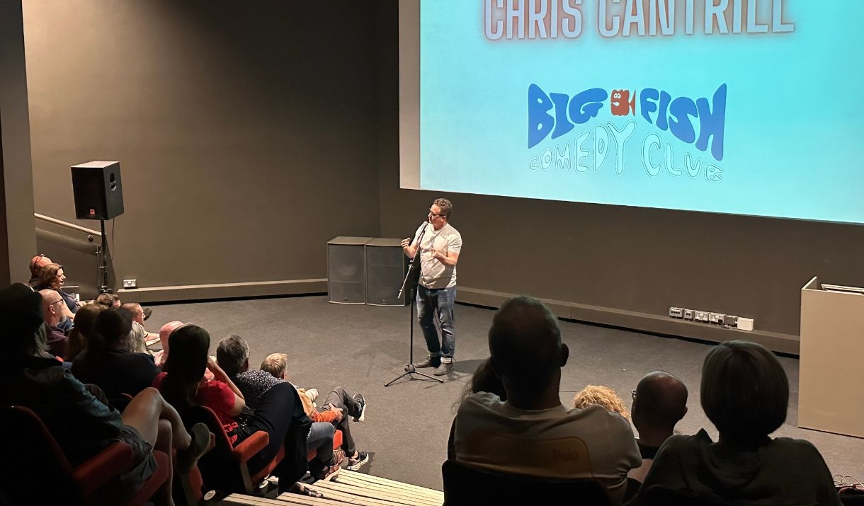 Big Fish Comedy Club live performance involving a crowd watching a male comedian on stage