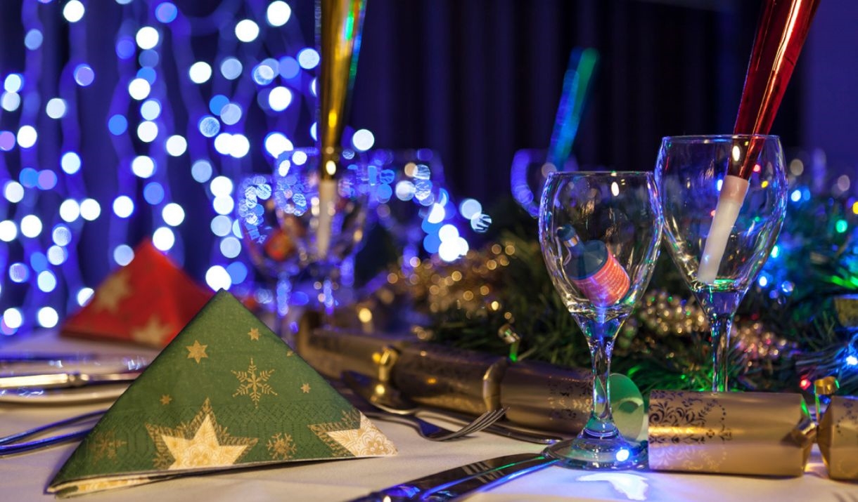 Picture of a Christmas party dinning table with crackers and fairy lights