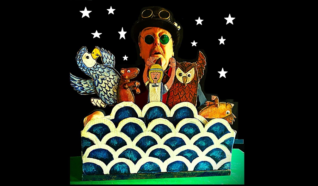 A puppeteer holding up character from the children book "Alice in Wonderland"